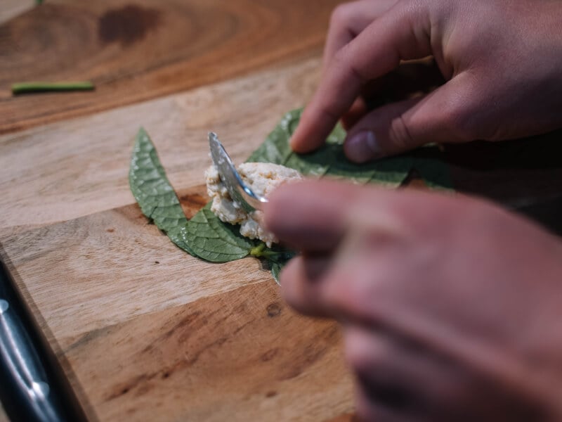 A fork adding rice to a leaf at a cooking class.